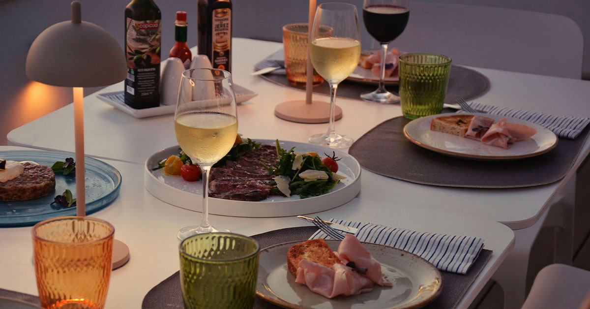 dietro al sole mesa con platos y copas de vino